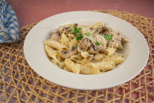 Penne pasta with Alfredo sauce, mushroom and parmesan cheese grated on the top  