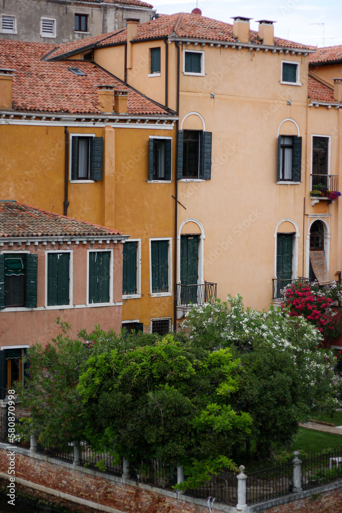 Colored houses in the Italian courtyard, green trees Colored houses in the Italian courtyard, green trees