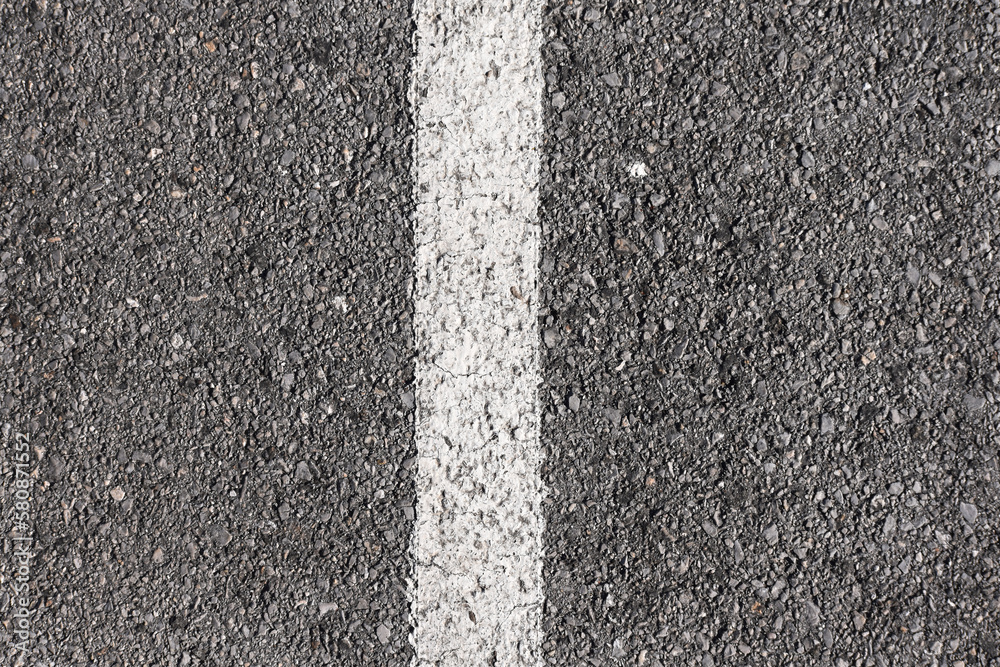 Fototapeta premium Background gray dry asphalt top view with a white marking line in the center