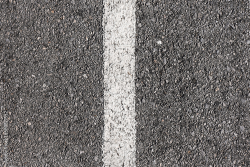 Background gray dry asphalt top view with a white marking line in the center