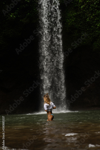 Fototapeta Naklejka Na Ścianę i Meble -  Woman tourist at a waterfall in the tropical jungle, Bali.