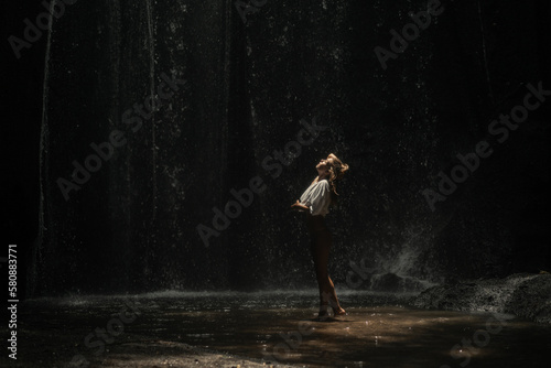 Woman tourist at a waterfall in the tropical jungle, Bali.