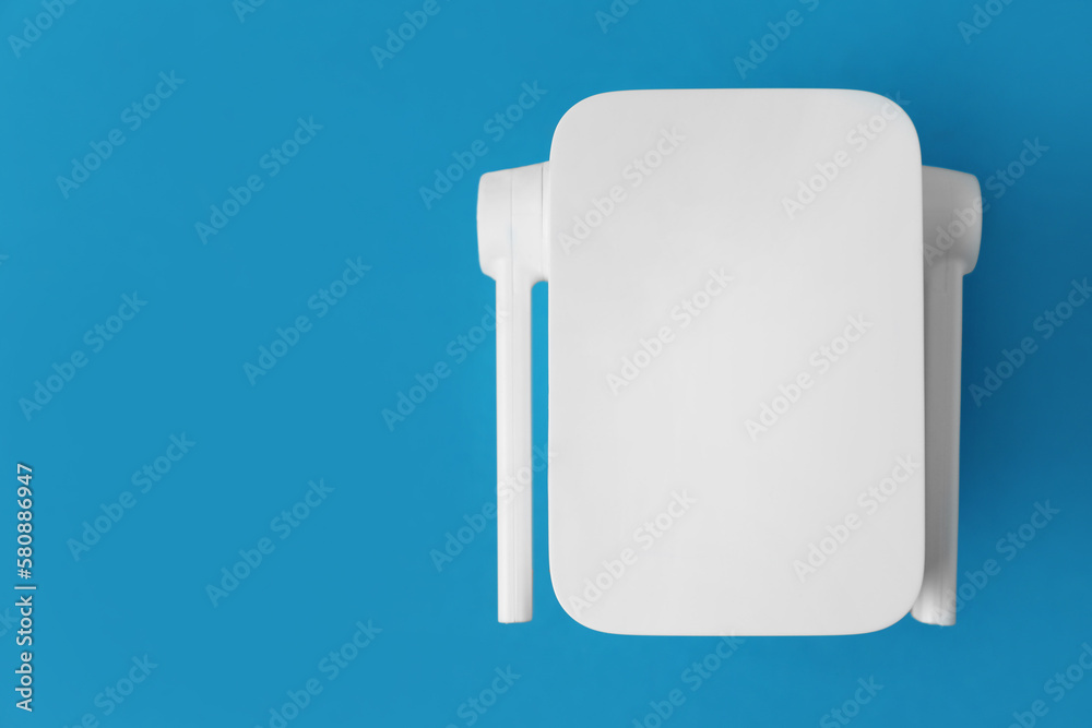 New modern Wi-Fi repeater on blue background, top view. Space for text New modern Wi-Fi repeater on blue background, top view. Space for text