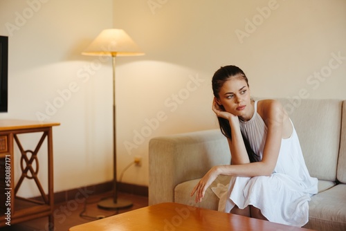 Sad woman depressed sitting on the couch at home, anxiety disorder alone without the help of a psychologist