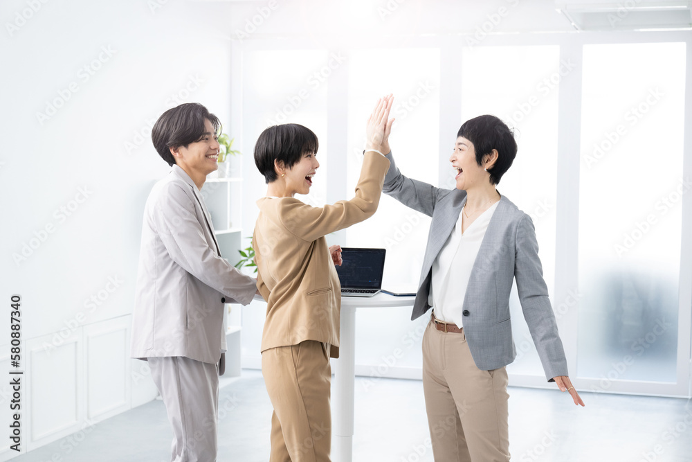 ハイタッチをして仕事の成功を喜ぶチーム ハイタッチをして仕事の成功を喜ぶチーム