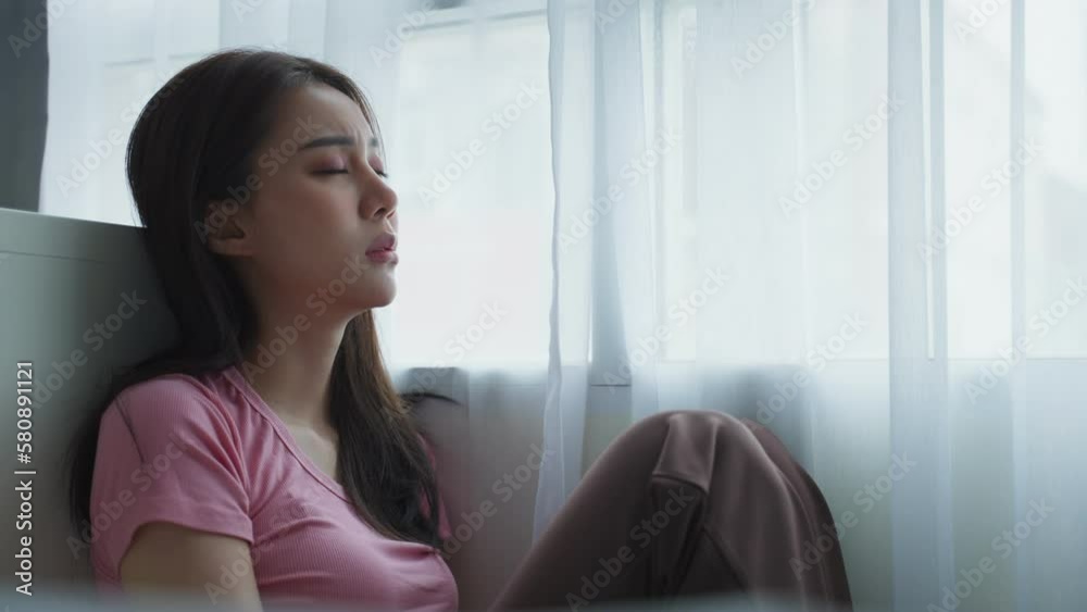 Asian young upset depressed woman sitting alone in living room at home. Asian young upset depressed woman sitting alone in living room at home.
