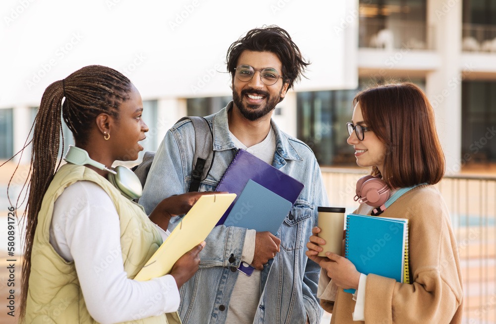 Happy young multiethnic people students in casual with headphones, notebooks study, communicate Happy young multiethnic people students in casual with headphones, notebooks study, communicate