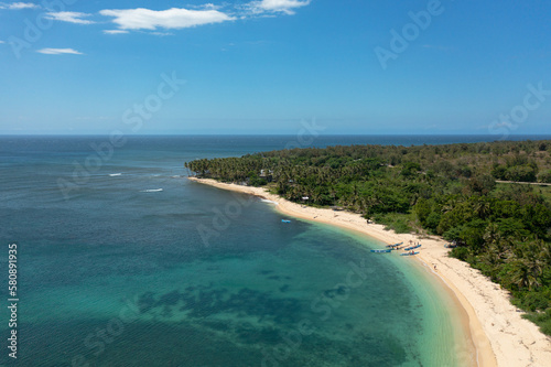 Fototapeta Naklejka Na Ścianę i Meble -  Beautiful sandy beach with palm trees and sea surf with waves. Pagudpud, Ilocos Norte Philippines