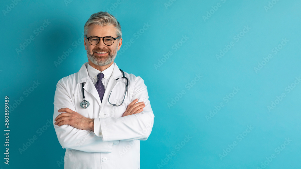 Portrait of positive european doctor posing on blue Portrait of positive european doctor posing on blue