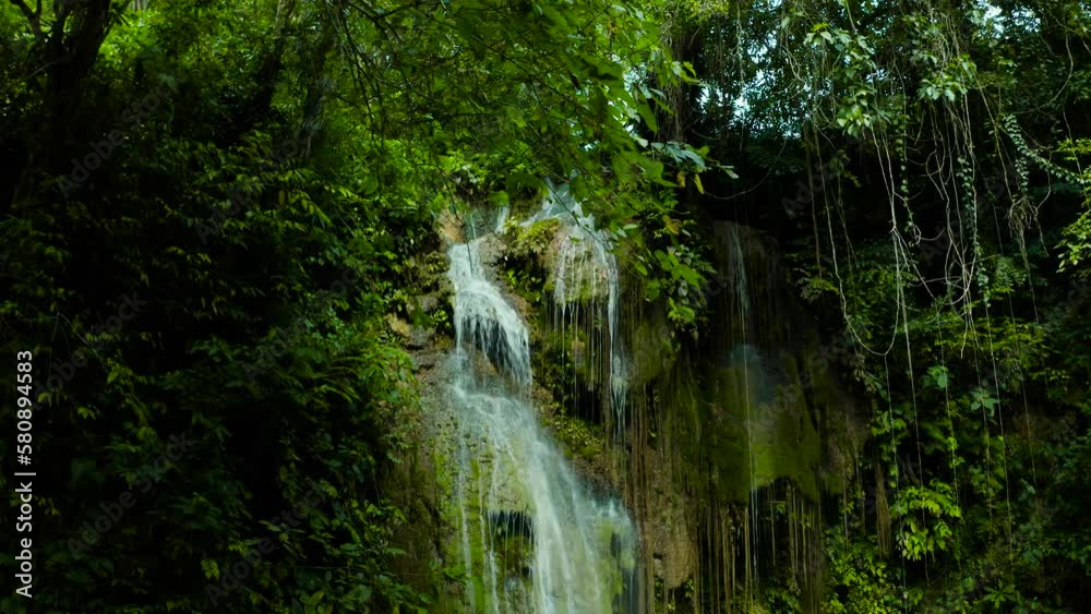 Beautiful waterfall in green forest, top view. Tropical Cambais Falls in mountain jungle, Philippines, Cebu. Waterfall in the tropical forest. Beautiful waterfall in green forest, top view. Tropical Cambais Falls in mountain jungle, Philippines, Cebu. Waterfall in the tropical forest.