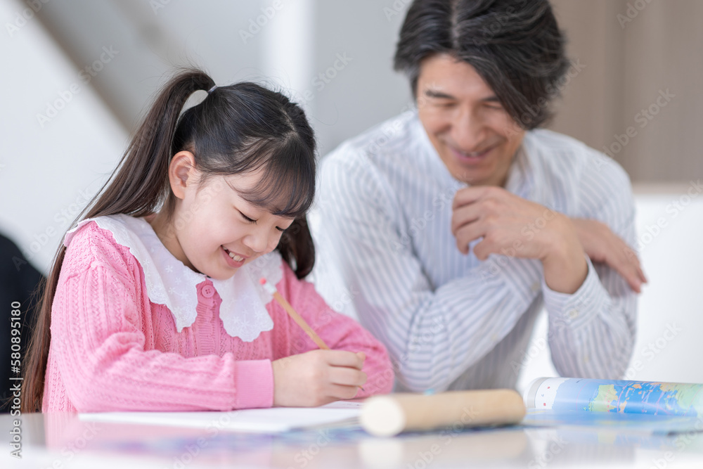 勉強をする子供と教える父 勉強をする子供と教える父