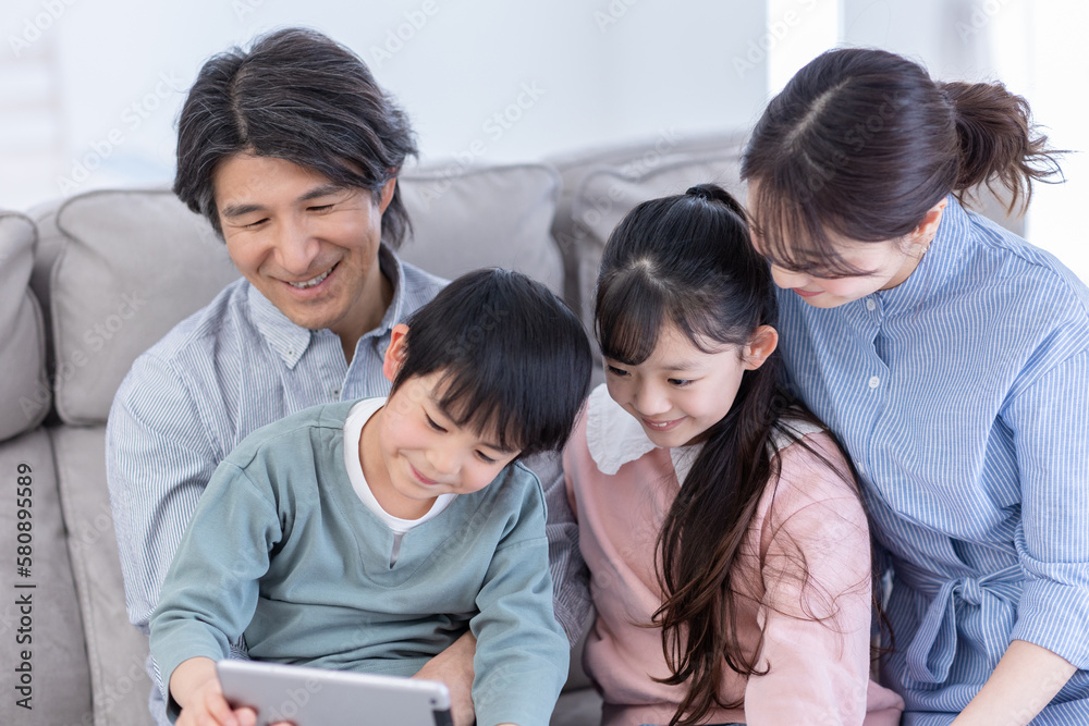 タブレットを覗き込む家族 タブレットを覗き込む家族