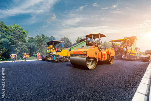 Obraz na plátne Construction site is laying new asphalt pavement, road construction workers and road construction machinery scene