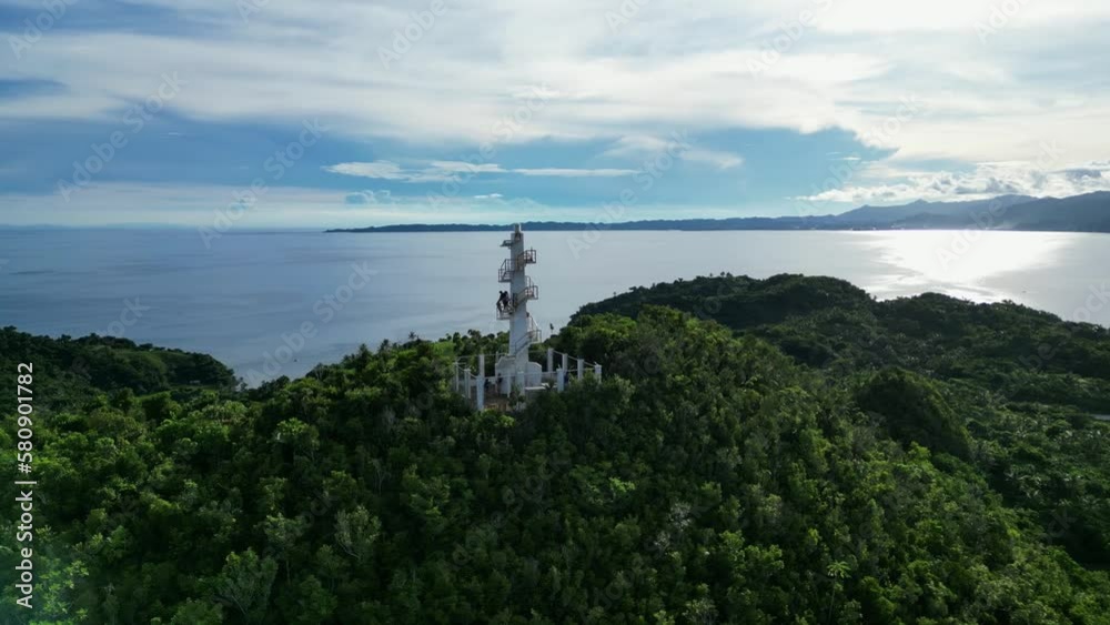 Orbiting Aerial view of birds flying around Bote lighthouse atop rainforest mountain with vast, pristine ocean and breathtaking clouds in background. Orbiting Aerial view of birds flying around Bote lighthouse atop rainforest mountain with vast, pristine ocean and breathtaking clouds in background.