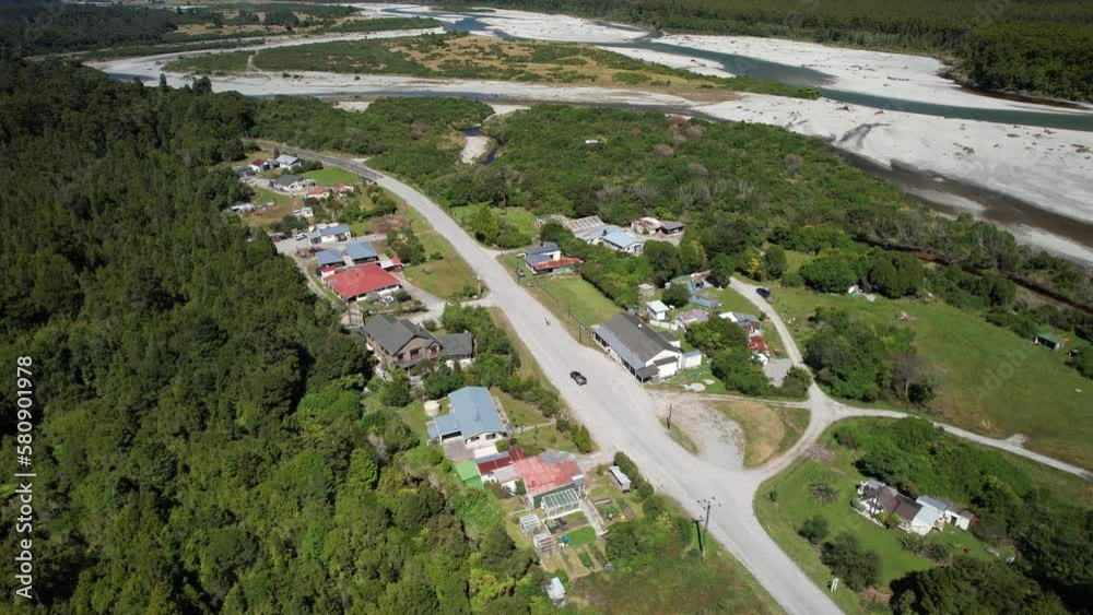 Homes in tiny settlement by river delta, mountain vista reveal. Bruce