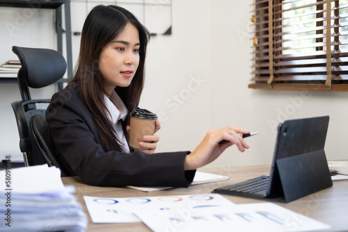 Young thoughtful Asian business woman executive manager wearing suit working in modern office  taking notes and thinking of professional plan  project management  considering new business ideas.