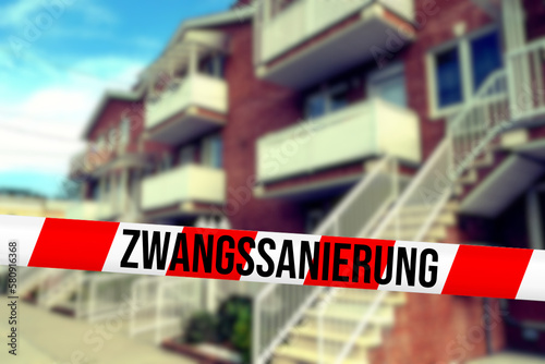 Ein Haus und Hinweis auf Zwangssanierung wegen Öl- und Gasheizungsverbot photo