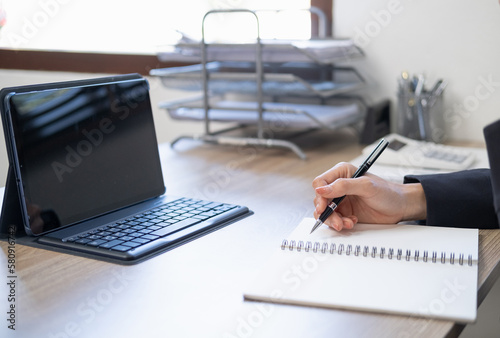 Business woman working at office with laptop and documents on his desk, Business woman holding pens and papers making notes in documents on the table, Hands of financial manager taking notes