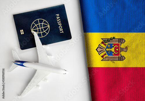 Flag of Moldova with passport and toy airplane. Flight travel concept 