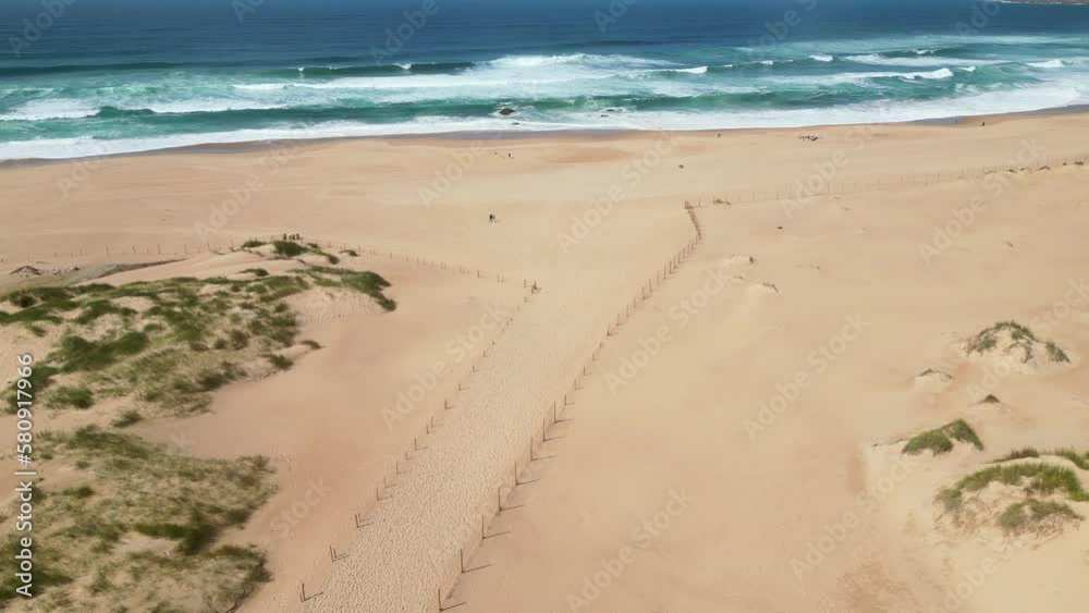 Flying over the extensive sand of Guincho beach towards the sea with the waves crashing, Cascais,Portugal Flying over the extensive sand of Guincho beach towards the sea with the waves crashing, Cascais,Portugal