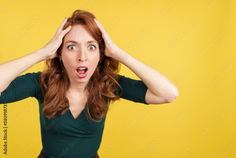 Obraz premium Surprised redheaded woman gesturing and looking at the camera