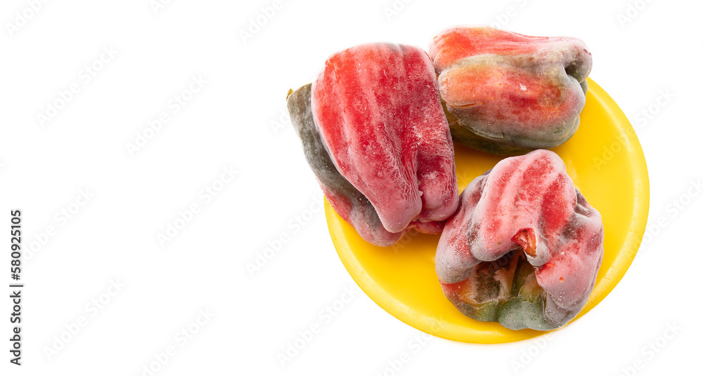 Frozen bell pepper in yellow plate isolated on white background.