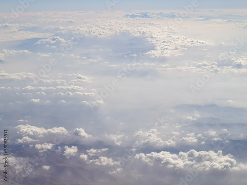 Clouds above the earth as a background. View from the airplane window.