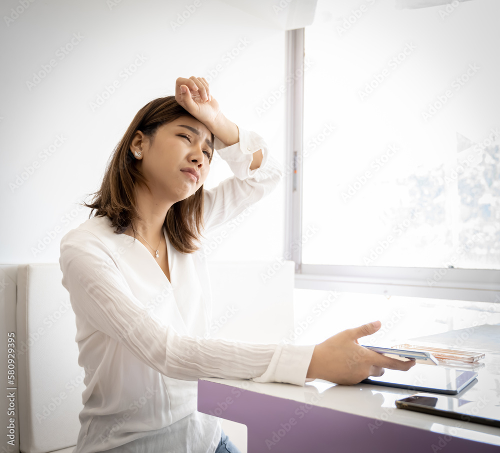 Beautiful asian business woman is tired from work with sad face while sitting in her office. Beautiful asian business woman is tired from work with sad face while sitting in her office.