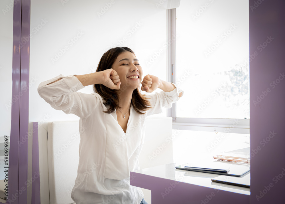 Young beautiful confident business woman sitting raised fists victory with smile on her face.