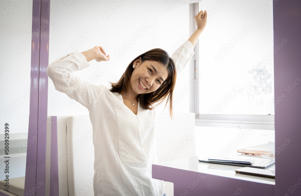 Beautiful asian businesswoman or working lady is stretch themselves or lazily for relaxation on their desk in her office. Beautiful asian businesswoman or working lady is stretch themselves or lazily for relaxation on their desk in her office.