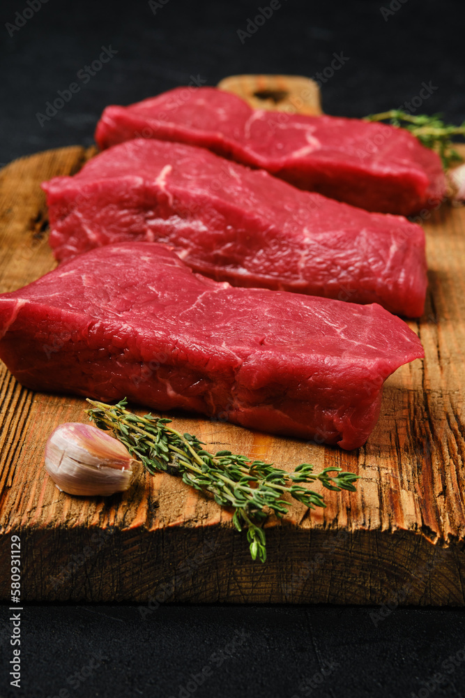 Closeup view of raw beef steak on cutting board Closeup view of raw beef steak on cutting board