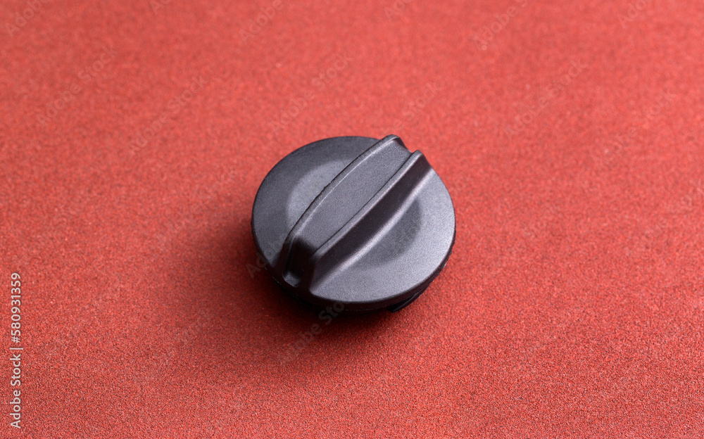 Black car oil filler plug on brown background, close-up Black car oil filler plug on brown background, close-up