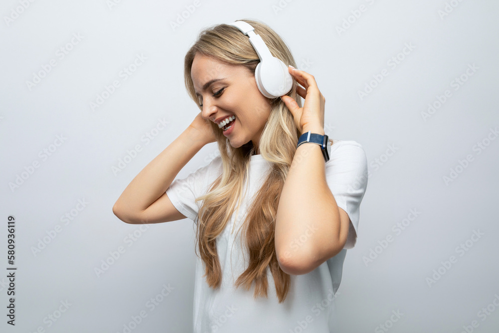 romantic woman sings along to music from headphones among white background romantic woman sings along to music from headphones among white background