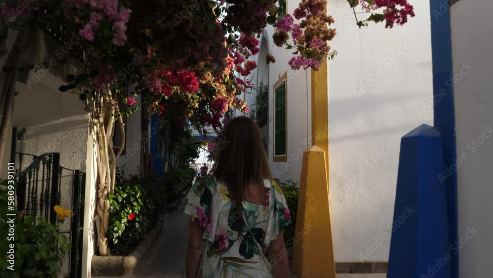woman walks through the streets of Puerto de Mogan during sunset. On the island of Gran Canaria.