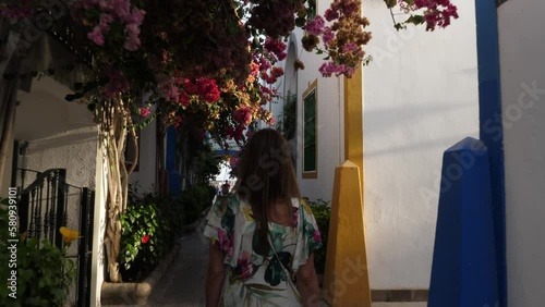 woman walks through the streets of Puerto de Mogan during sunset. On the island of Gran Canaria. photo
