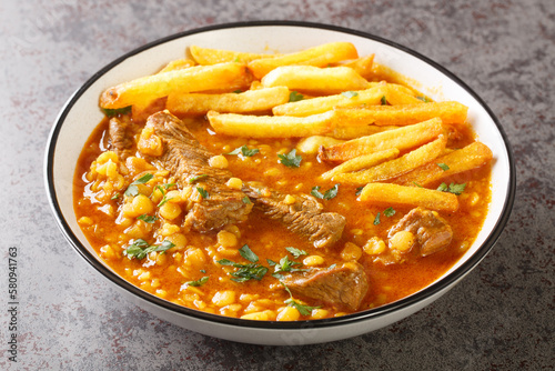 Khoresh Gheymeh yellow split peas, saffron, tomato paste, diced meat, and sun-dried lime are the main ingredients of this delicious stew closeup on a plate on the table. Horizontal photo