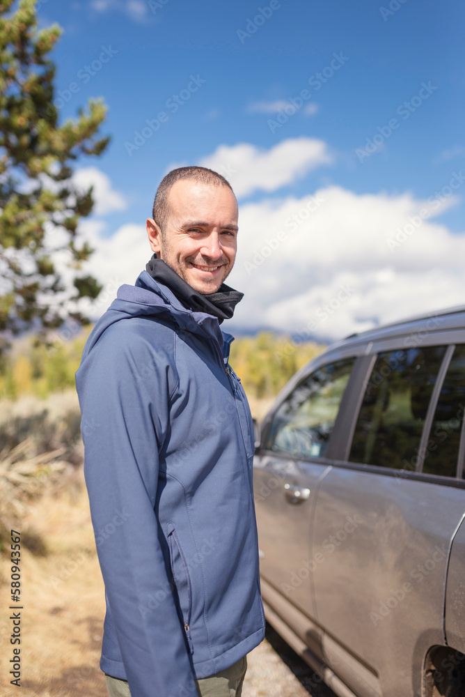 Portrait of smiling man standing by car at Grand Teton National Park Portrait of smiling man standing by car at Grand Teton National Park