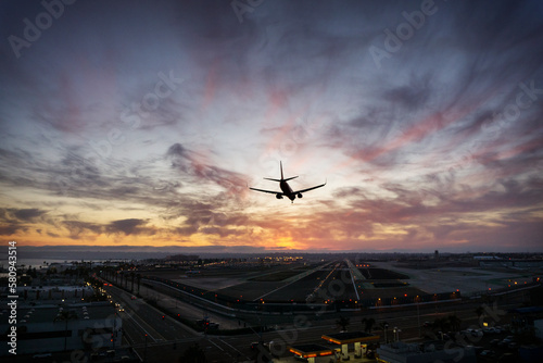 Silhouette airplane landing at airport photo