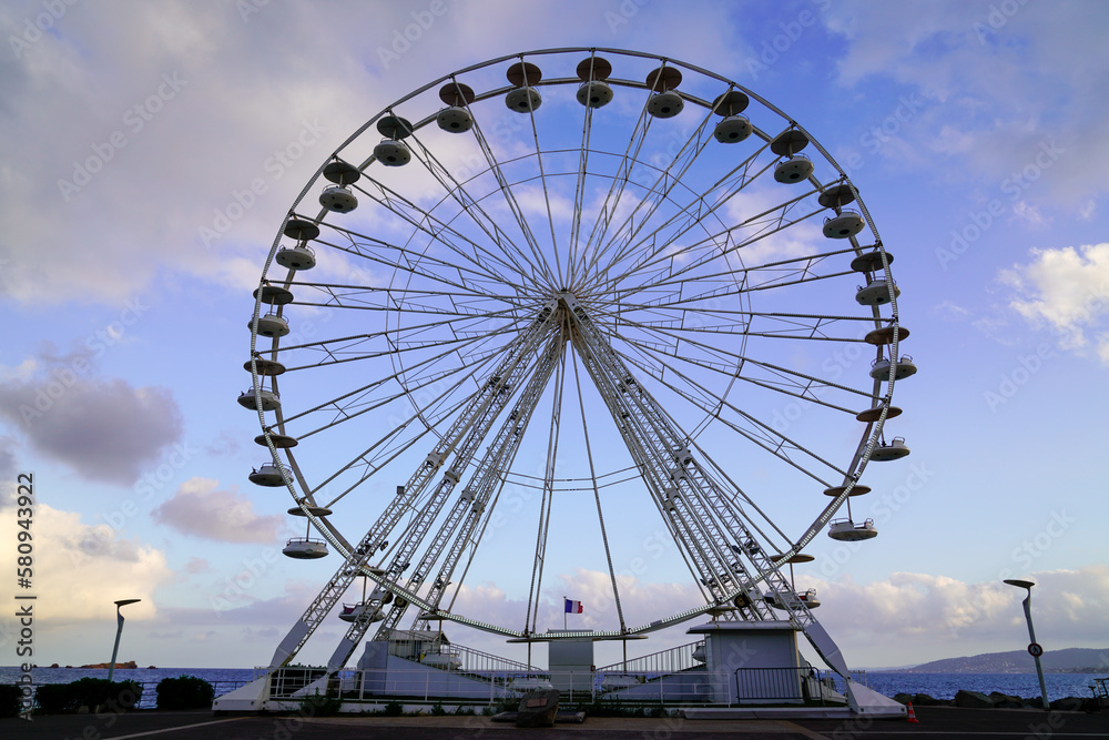 Ferris wheel circle fun fair on blue cloud sky background