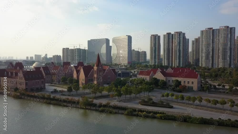 Clock tower on river waterfront of tall modern Suzhou city in China