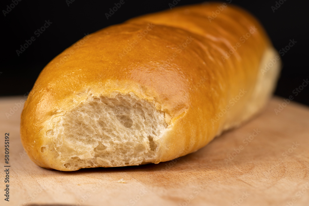 Wheat baguette on a wooden cutting board