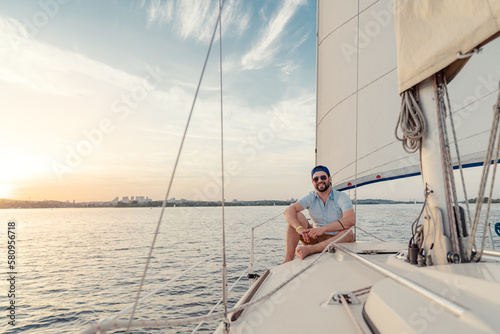 Luxury travel on the yacht. Young happy man on boat deck sailing the river.