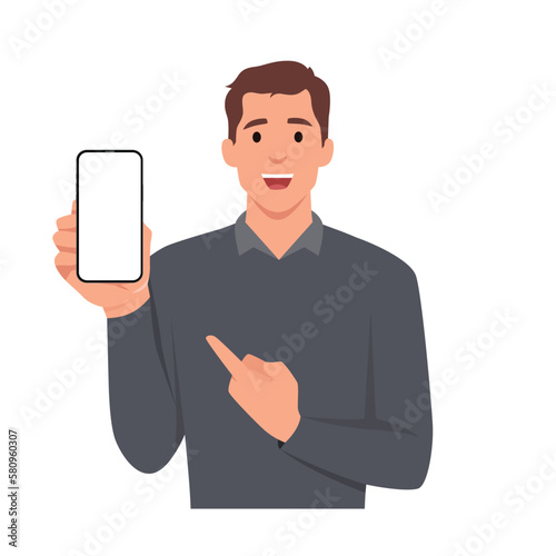 Stylish young businessman in vest suit showing blank mobile, cell phone and pointing finger. Trendy person holding smartphone screen