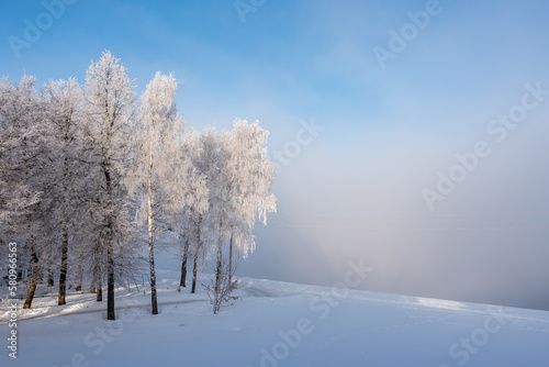 Winter morning landscape with river, water, forest and steam on the water. 