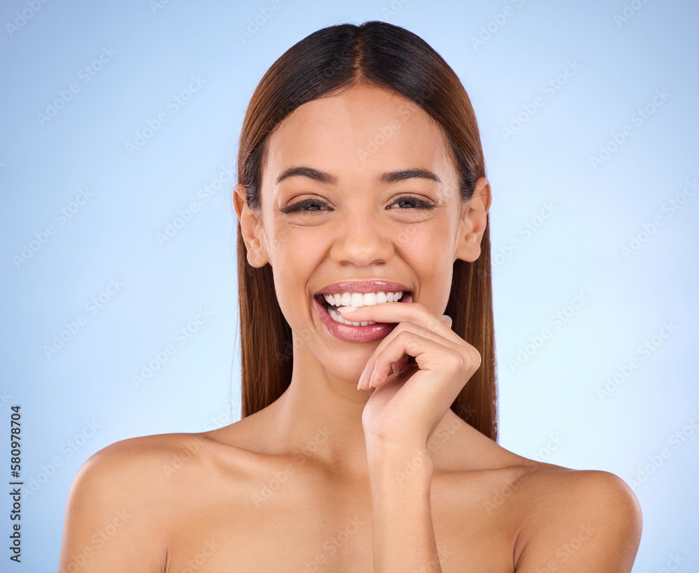 Beauty, woman and biting finger portrait for skincare dermatology cosmetics in studio. Female model person on a blue background for self care, facial glow and healthy or clean skin with a smile Beauty, woman and biting finger portrait for skincare dermatology cosmetics in studio. Female model person on a blue background for self care, facial glow and healthy or clean skin with a smile