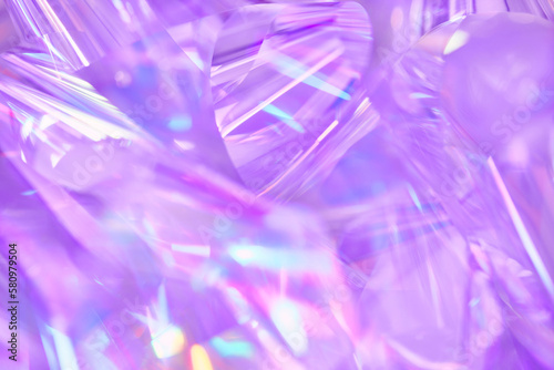 Close-up of ethereal pastel neon blue, purple, lavender, pink holographic metallic foil background. Abstract modern curved blurred surreal futuristic disco, rave, techno, festive dreamlike backdrop © Aleksandra Konoplya