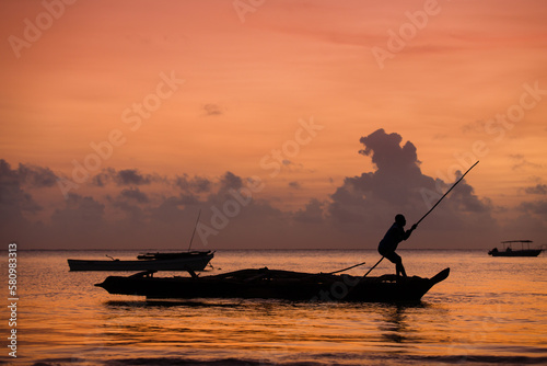 Zanzibar fisherman on the traditional boat in the sunrise light