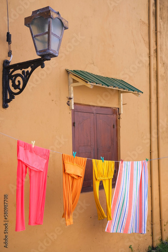 Colorful clothes drying on the clothline on historic old house photo