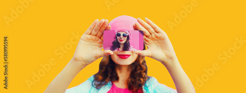 Close up of woman stretching her hands taking selfie with smartphone on orange background