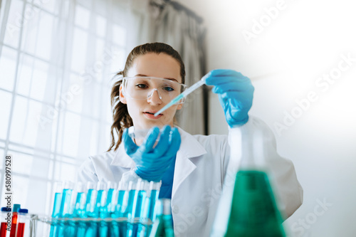 Female biotechnologist testing new chemical substances in laboratory.